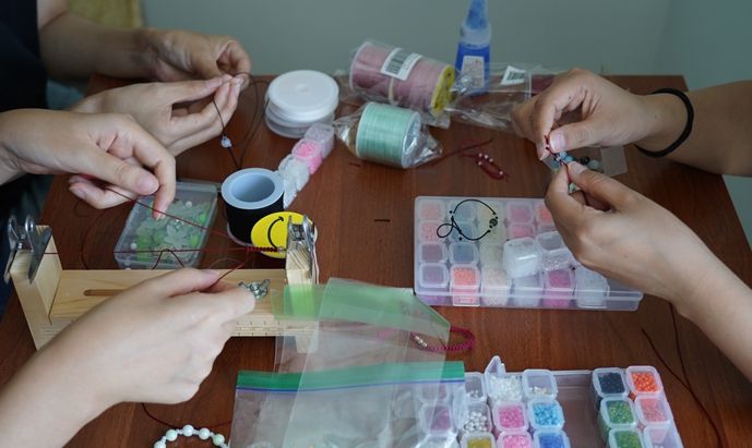 인천시청년미래센터 프로그램을 이용하는 청년들이 청년의 날 행사에서 판매할 비즈 장식 장신구를 만들고 있다.