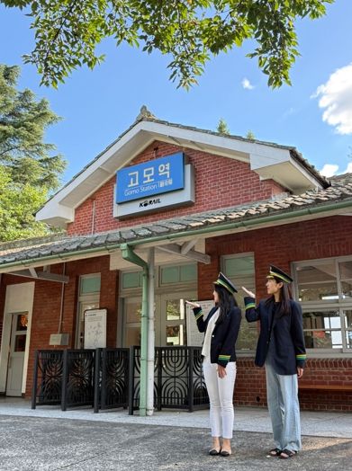 관광객들이 고모역에서 역무원 체험을 하고 있다.